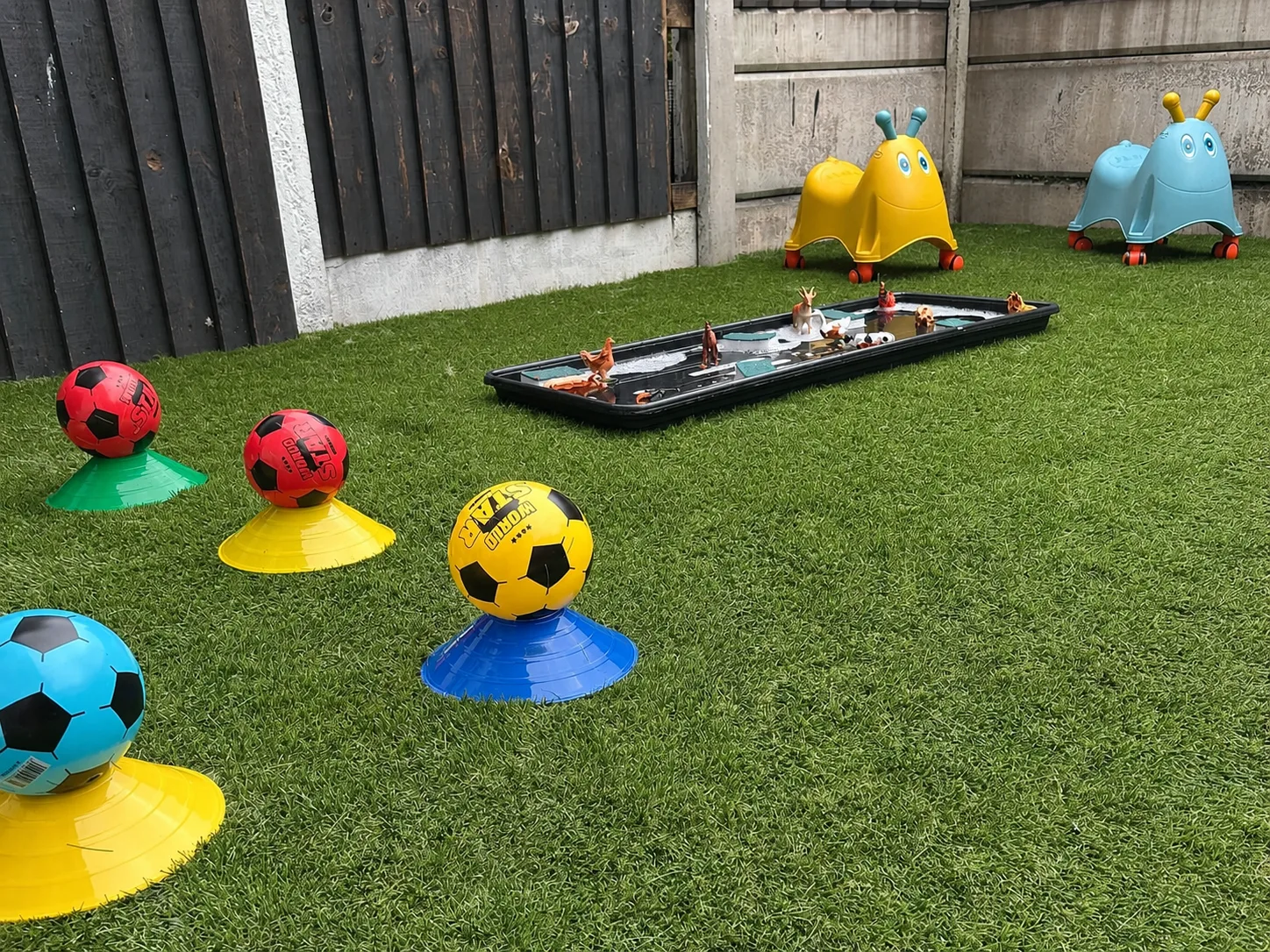 Colourful football targets and balls arranged as an outdoor obstacle course